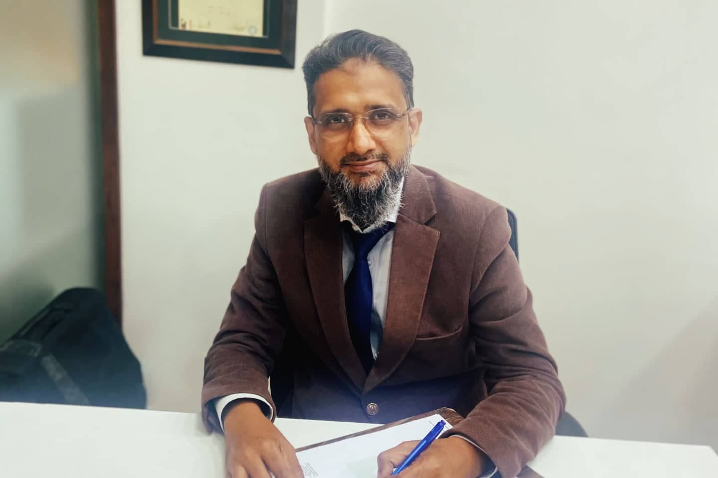 Dr Arshad at his clinic in Karachi, looking at the camera. Come visit us for all kinds of dental treatments in Karachi, Pakistan.